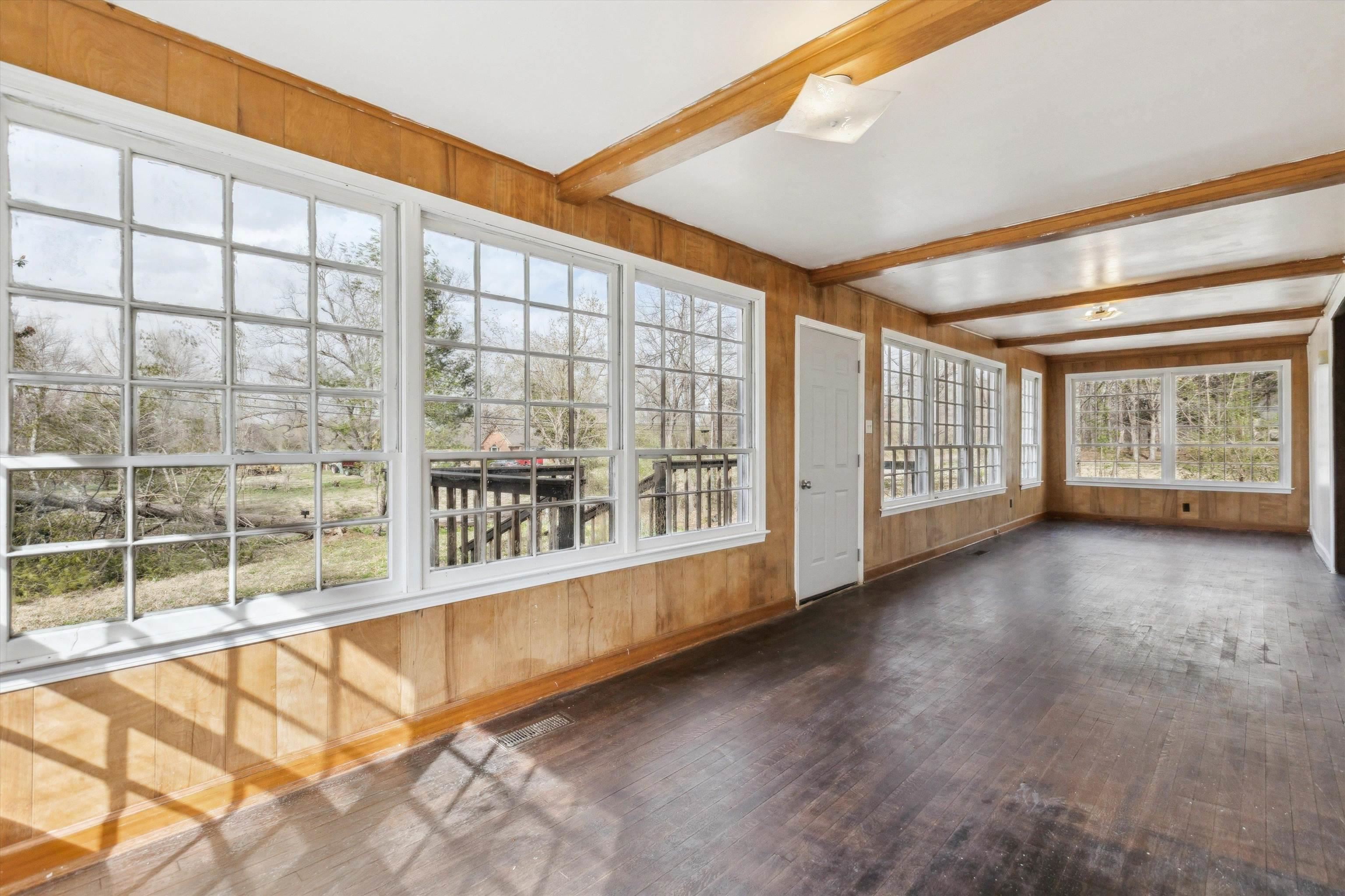 8457 East Kerrville Rosemark Road Millington, TN 38053 - Photo 9 of 32 Unfurnished sunroom with wooden walls, beam ceiling, and wood-type flooring