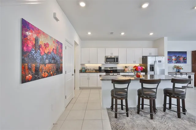 a kitchen with refrigerator and chairs