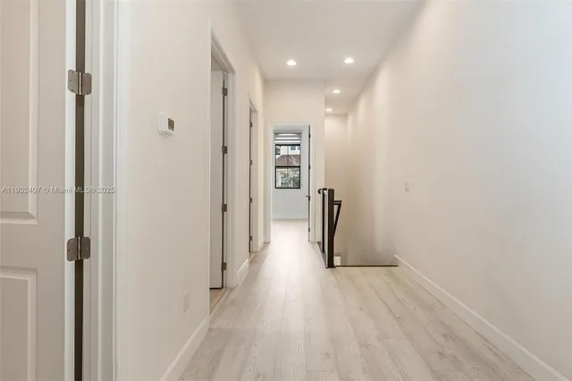a view of a hallway with wooden floor and closet