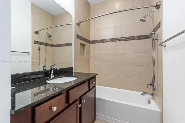a bathroom with a granite countertop sink mirror and a bathtub
