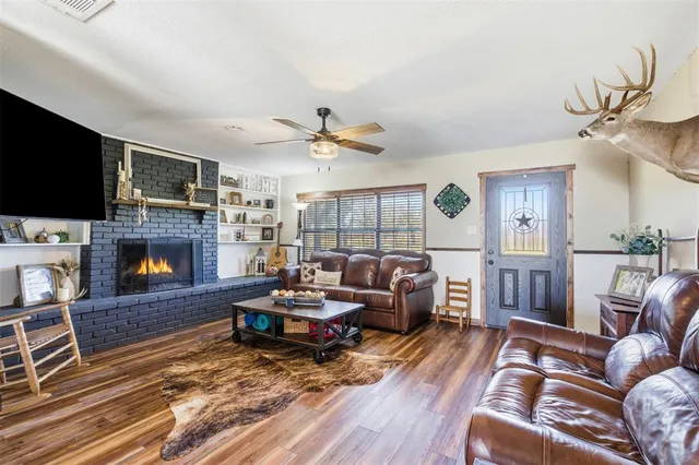 a kitchen with stainless steel appliances a refrigerator a stove a dining table and chairs with wooden floor