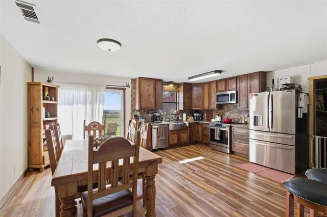 a kitchen with granite countertop furniture wooden floor and stainless steel appliances