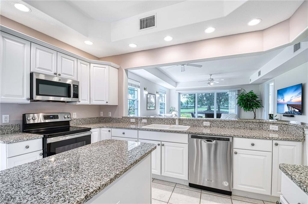 8649 Champions Point, Unit 1201 Naples, FL 34113 - Photo 6 of 23 Kitchen with Trey ceiling, granite counters open to living area