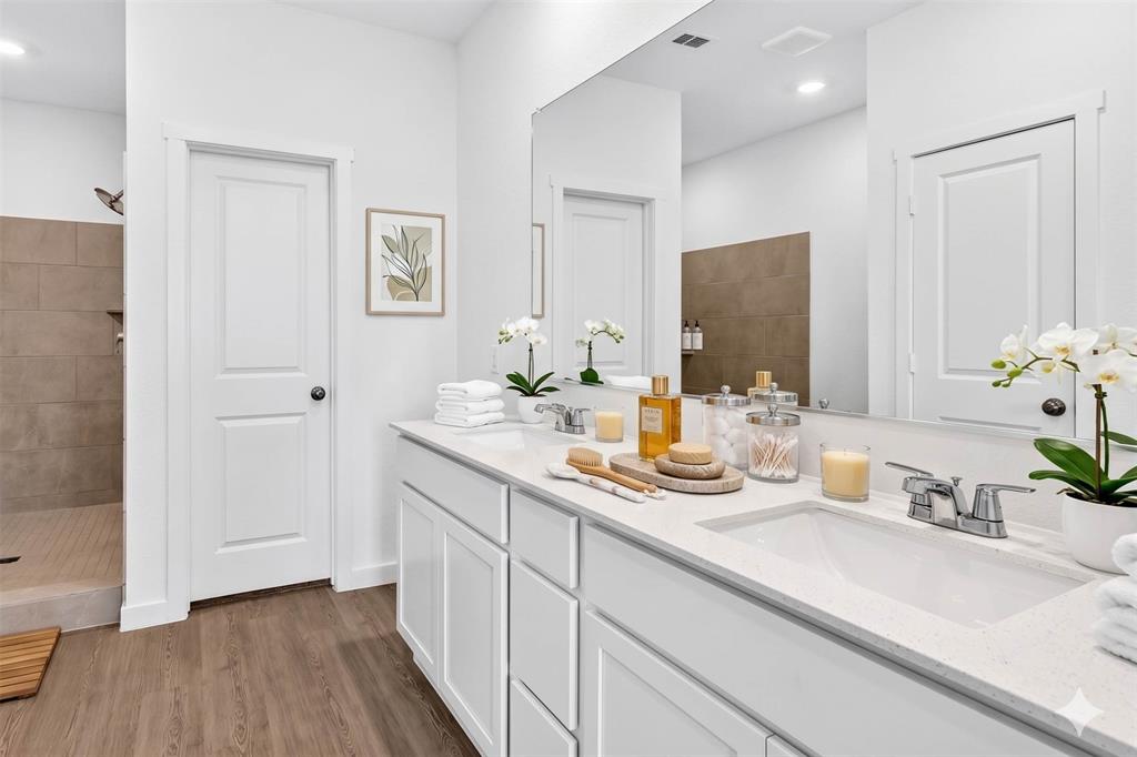 656 Waymaker Way Princeton, TX 75407 - Photo 8 of 40 Dual vanity with white cabinetry and integrated sinks, complemented by chrome faucets
