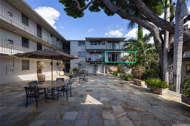 a view of a patio with a table and chairs under an umbrella