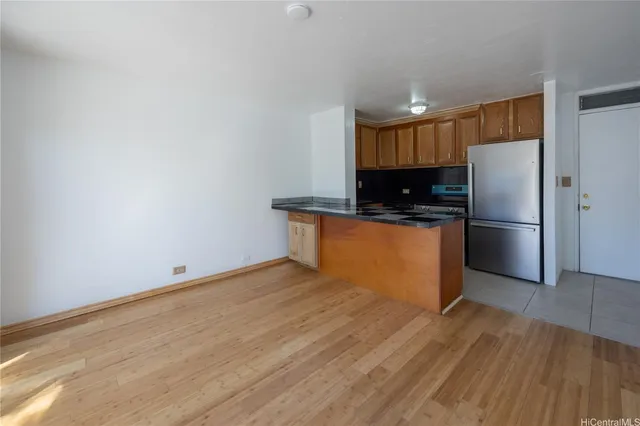a kitchen with granite countertop a refrigerator and a sink