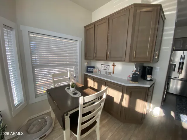 a kitchen with a chair and wooden cabinets