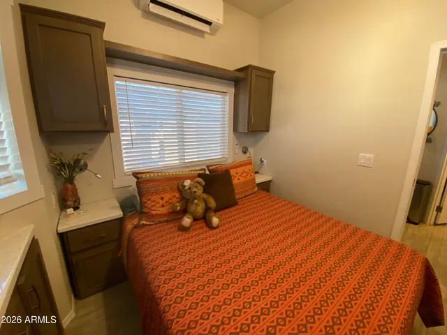 a bedroom with a bed and a flat tv screen on dresser