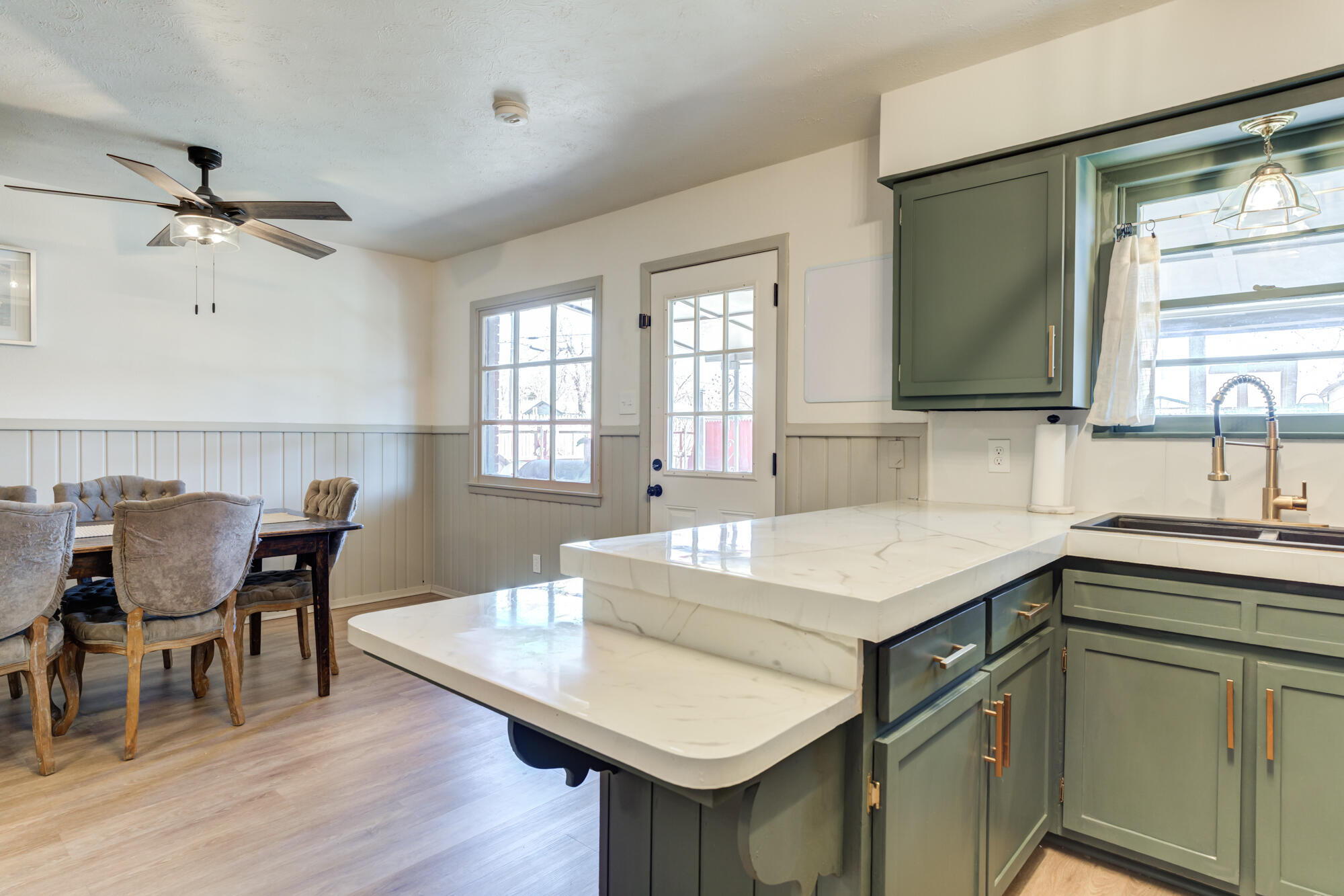 2101 64th Street Lubbock, TX 79412 - Photo 12 of 30 a kitchen that has a table chairs in it and wooden floors