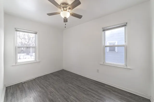 an empty room with a window and wooden floor