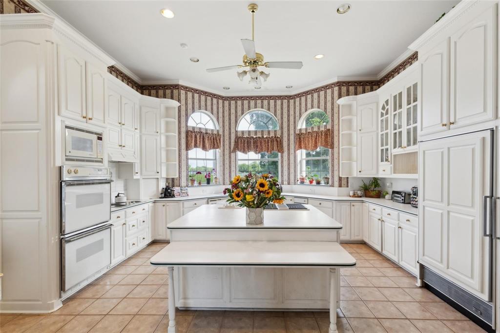 800 John McCain Road Colleyville, TX 76034 - Photo 35 of 38 a large white kitchen with granite countertop a stove a sink dishwasher and a refrigerator with wooden floor