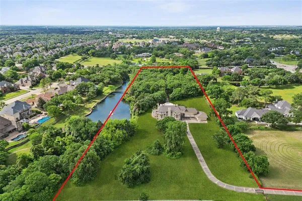 an aerial view of residential houses with outdoor space and trees