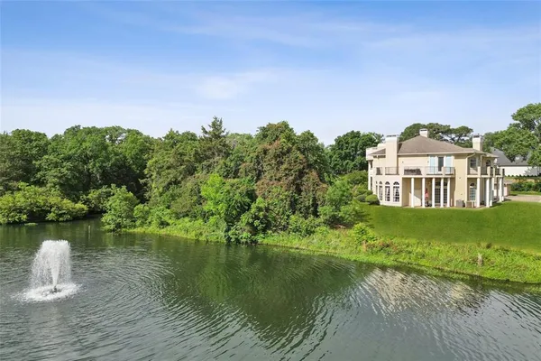 an aerial view of a house with a yard and lake view