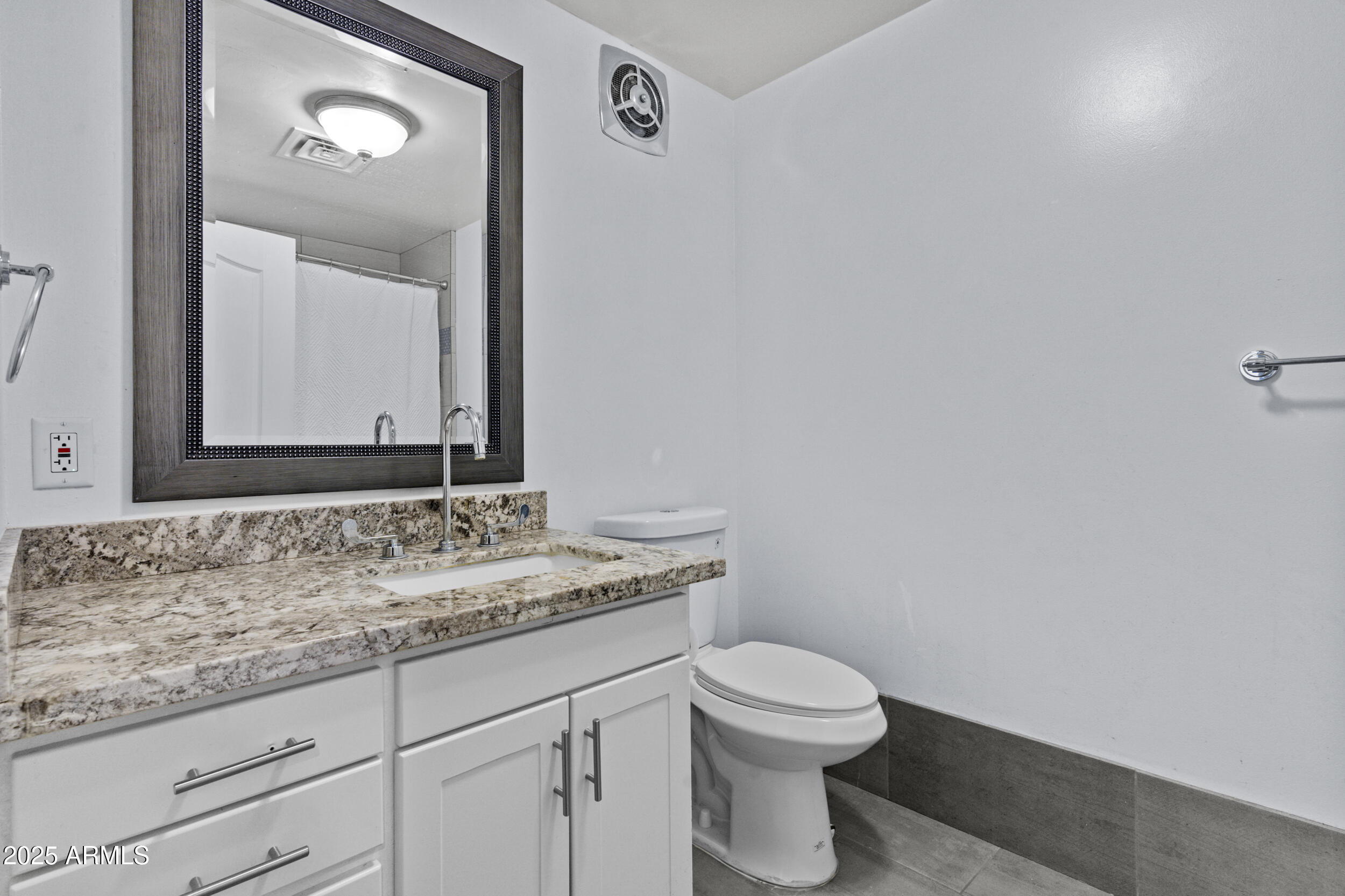 6125 East Indian School Road, Unit 247 Scottsdale, AZ 85251 - Photo 12 of 13 a bathroom with a granite countertop toilet sink and mirror