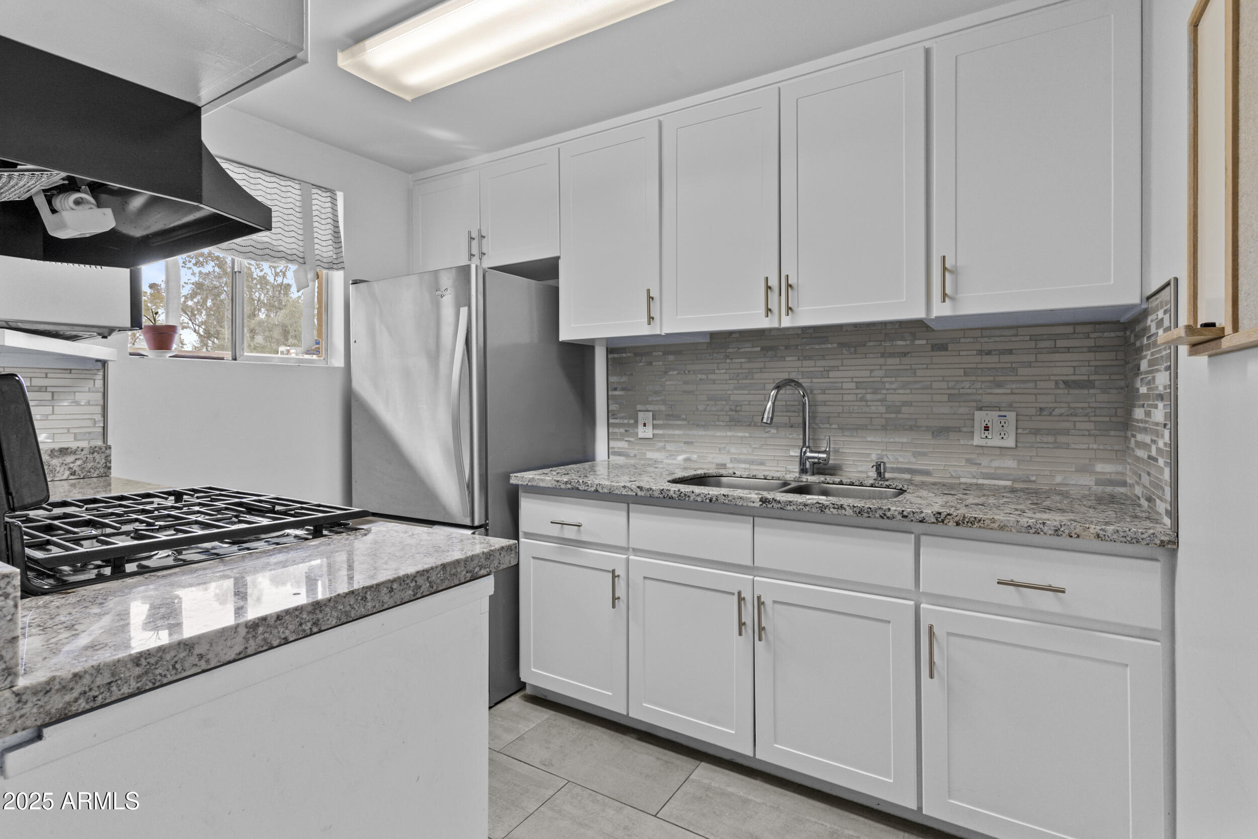 6125 East Indian School Road, Unit 247 Scottsdale, AZ 85251 - Photo 8 of 13 a kitchen with granite countertop a sink stove and cabinets