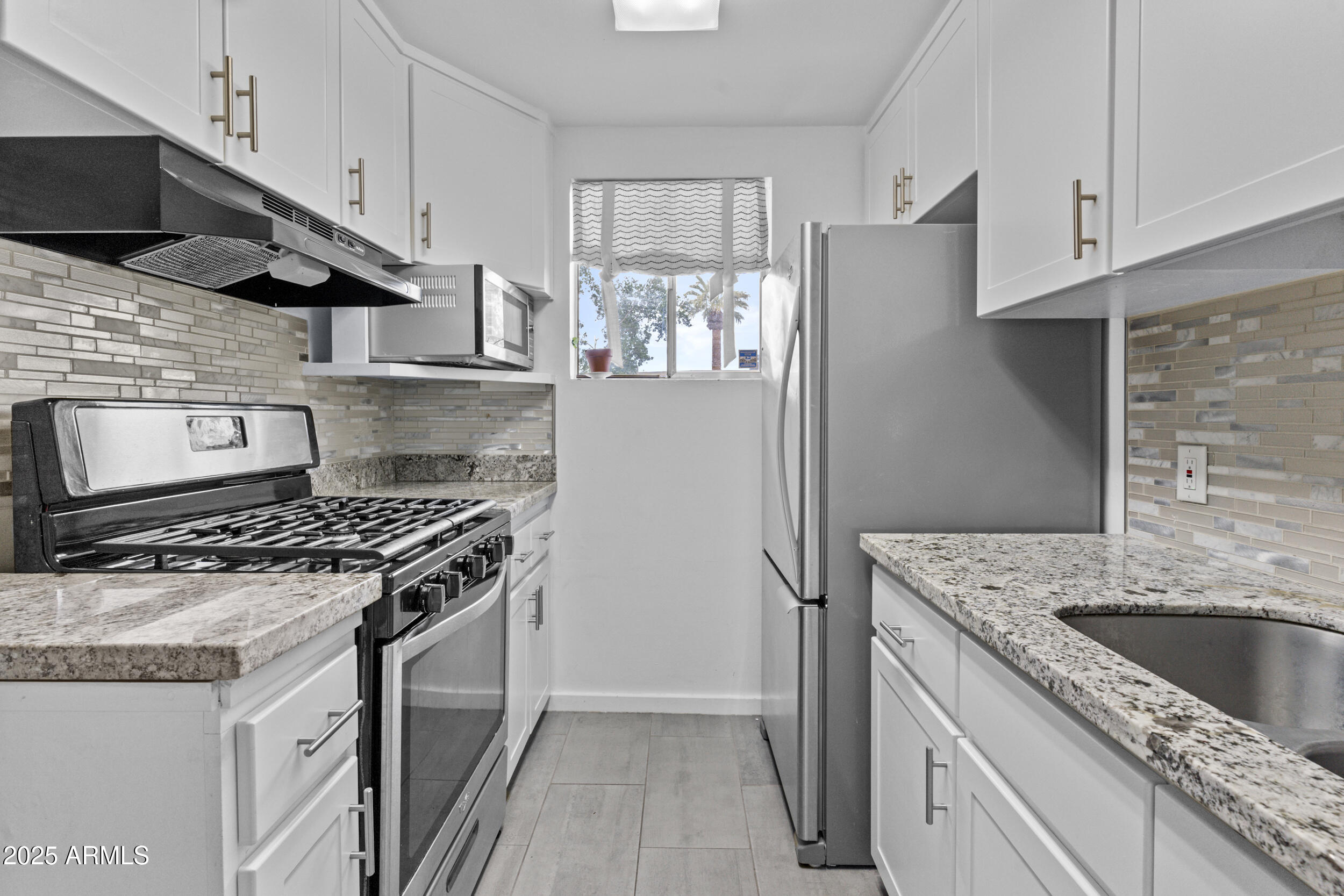6125 East Indian School Road, Unit 247 Scottsdale, AZ 85251 - Photo 9 of 13 a kitchen with stainless steel appliances granite countertop a sink stove and refrigerator