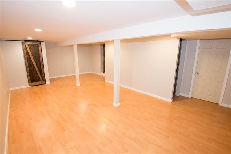 85 McClure Road Cheswick, PA 15024 - Photo 20 of 25 Large finished lower level family room with pergo flooring and two closets with barn doors.