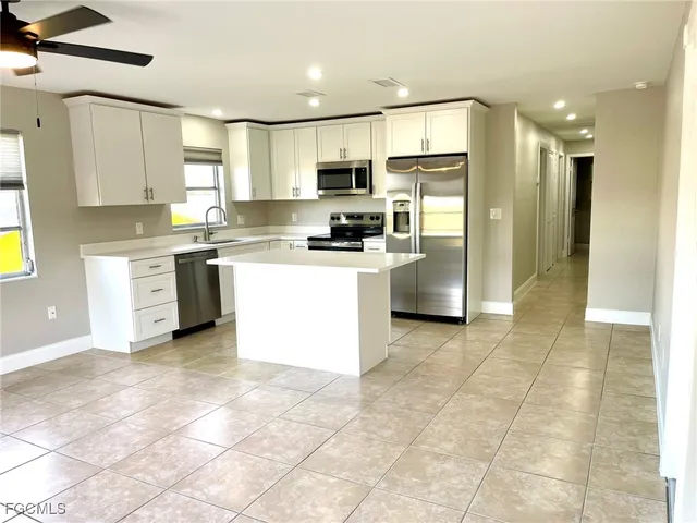 a kitchen with stainless steel appliances granite countertop a refrigerator a stove top oven and a sink