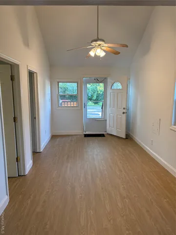 an empty room with windows and fireplace