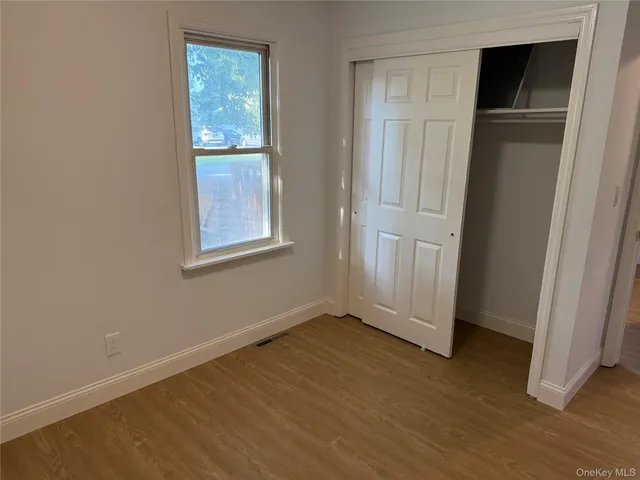 an empty room with windows and closet