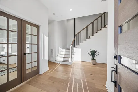 a view of a hallway with wooden floor and stairs
