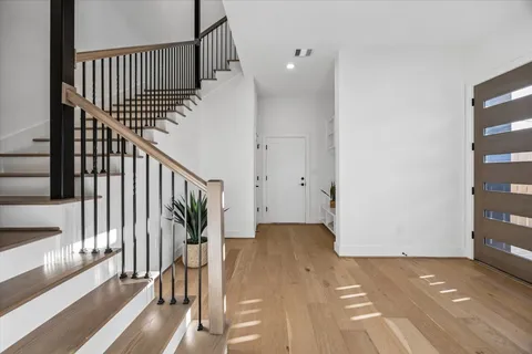 a living room with stainless steel appliances kitchen island granite countertop furniture and a wooden floor