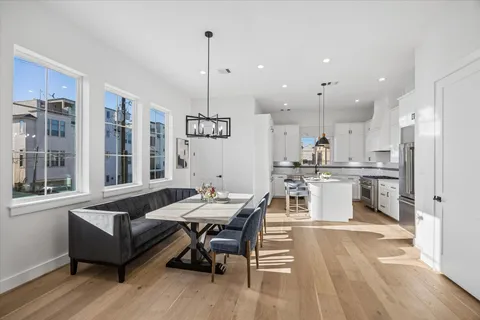 a kitchen with granite countertop a stove a sink a kitchen island with wooden cabinets and floor