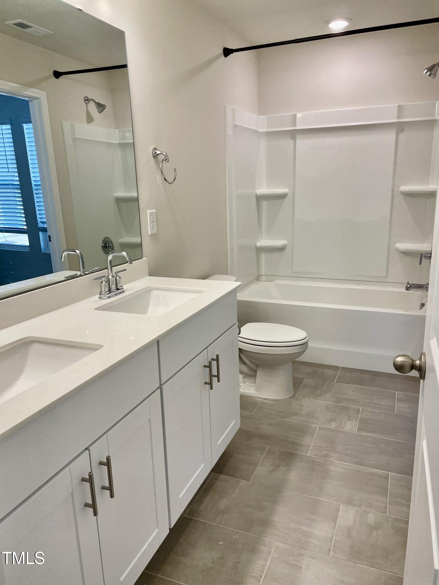 912 Field Ivy Drive Fuquay-Varina, NC 27526 - Photo 11 of 27 a bathroom with a sink a toilet and shower