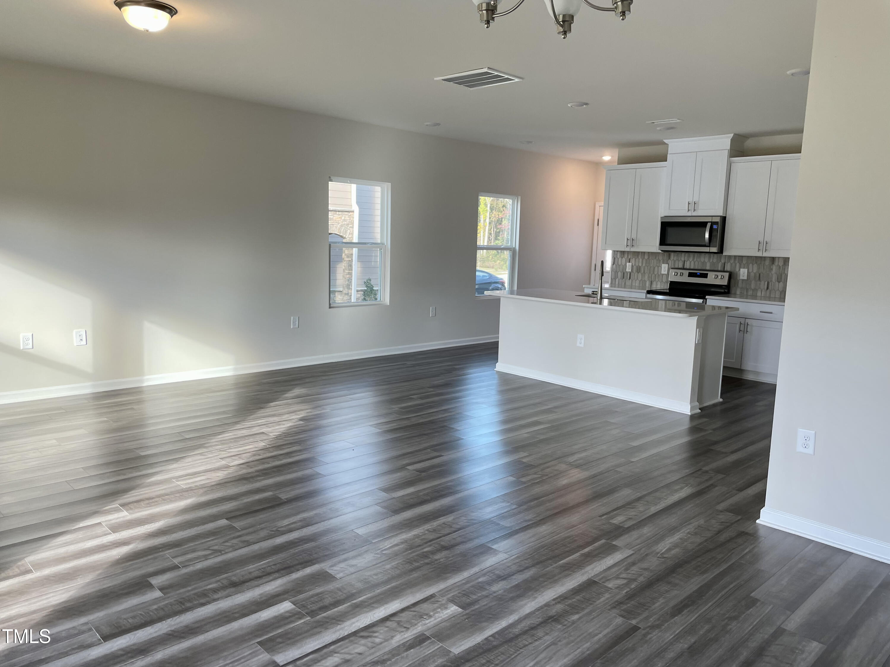 912 Field Ivy Drive Fuquay-Varina, NC 27526 - Photo 3 of 27 a view of kitchen and empty room with wooden floor