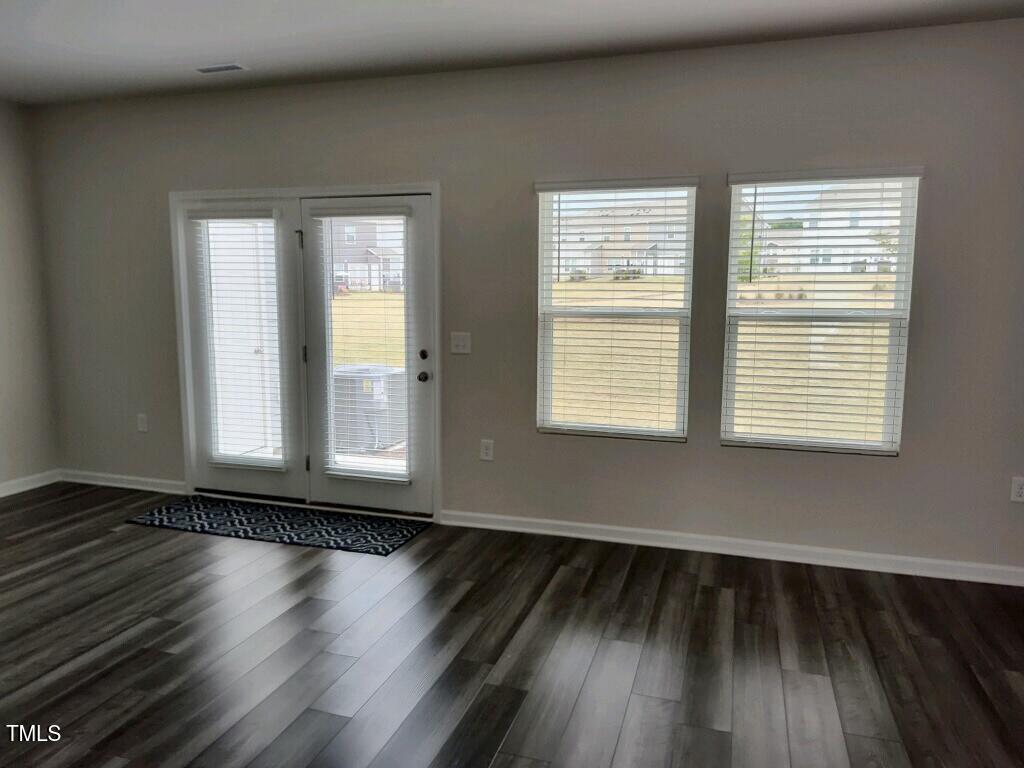 912 Field Ivy Drive Fuquay-Varina, NC 27526 - Photo 4 of 27 a view of an empty room with wooden floor and a window