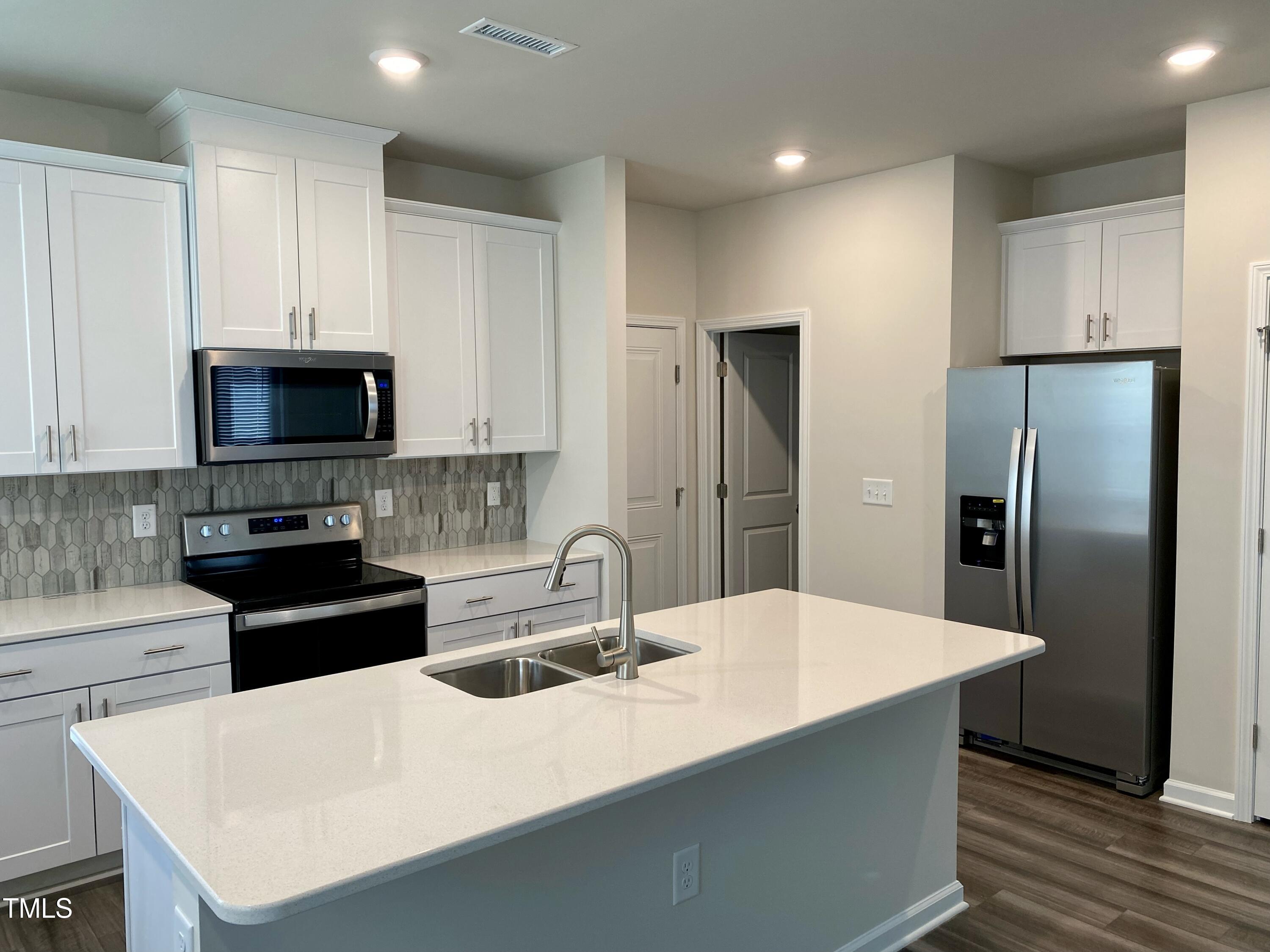 912 Field Ivy Drive Fuquay-Varina, NC 27526 - Photo 6 of 27 a kitchen with stainless steel appliances a refrigerator a sink a stove a microwave and island