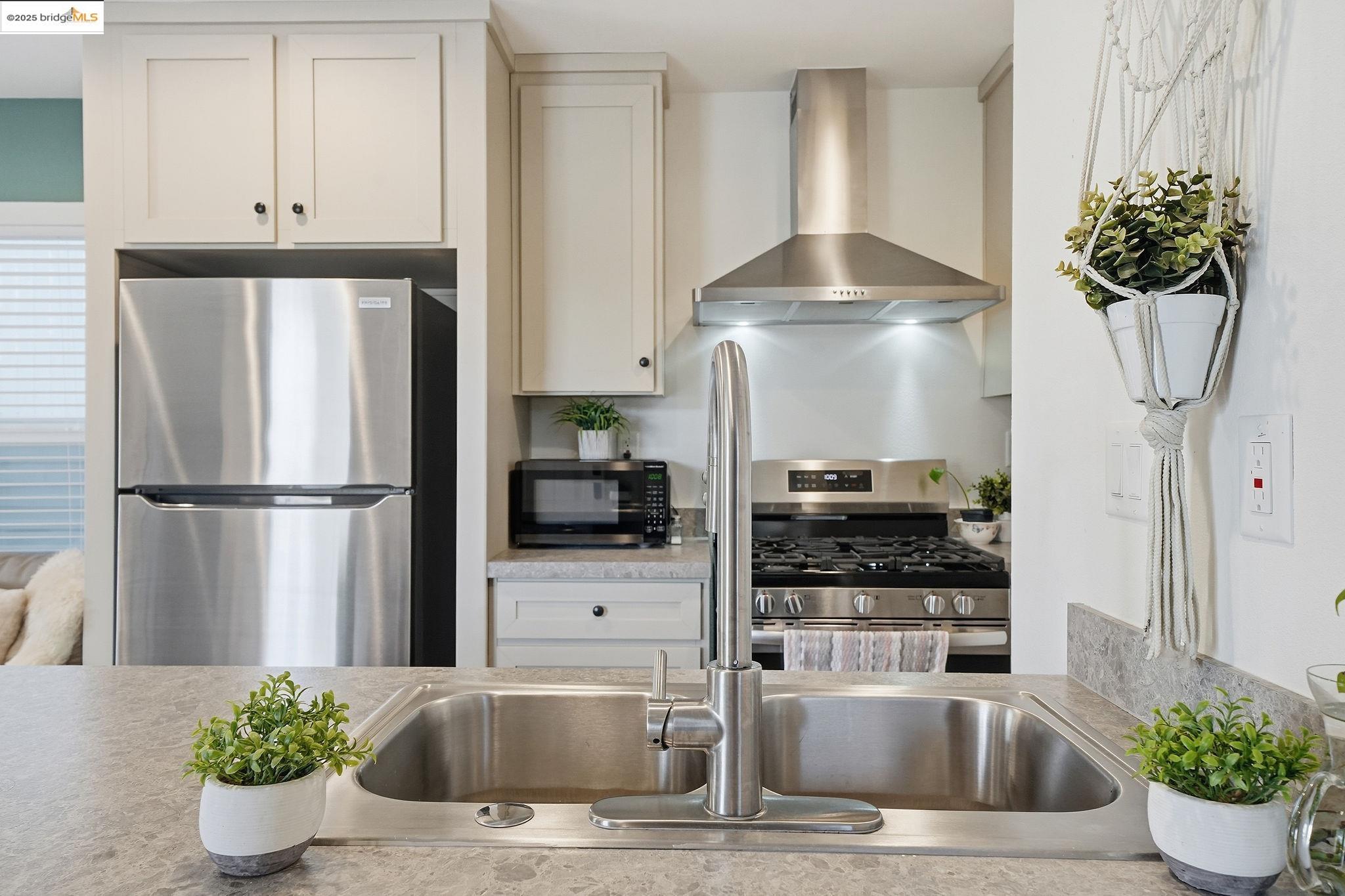 150 Clinton Road Jackson, CA 95642 - Photo 23 of 44 Kitchen featuring stainless steel appliances, wall chimney exhaust hood, and white cabinets