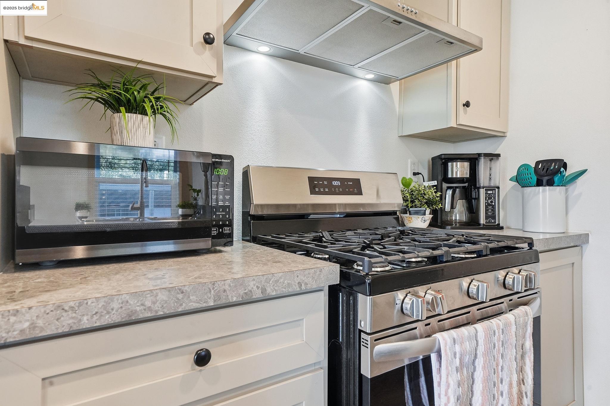 150 Clinton Road Jackson, CA 95642 - Photo 24 of 44 Kitchen with appliances with stainless steel finishes, range hood, light countertops, and white cabinets