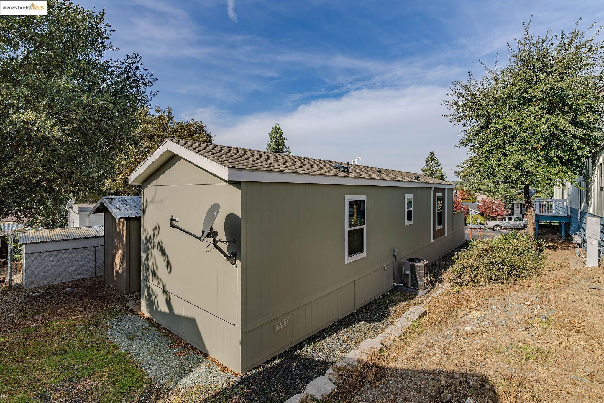 150 Clinton Road Jackson, CA 95642 - Photo 39 of 44 View of property exterior featuring a shingled roof and a cooling unit
