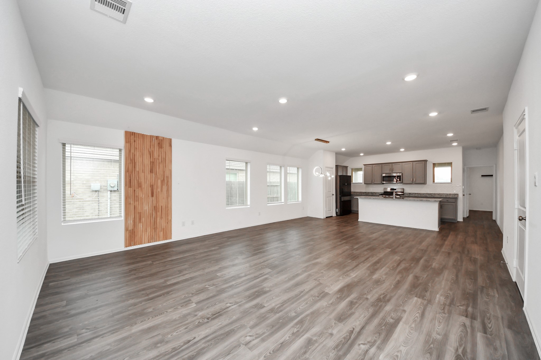 14230 Elrington Holw Trail Rosharon, TX 77583 - Photo 7 of 42 a view of an empty room with a window and wooden floor