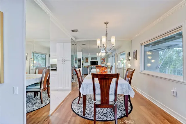 a dining room with furniture a chandelier and wooden floor