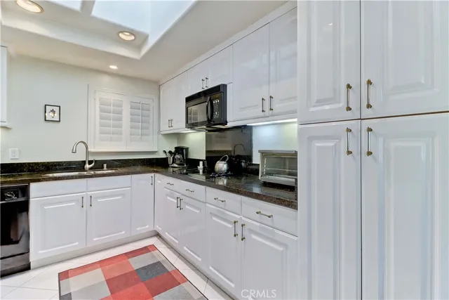 a kitchen with white cabinets and appliances