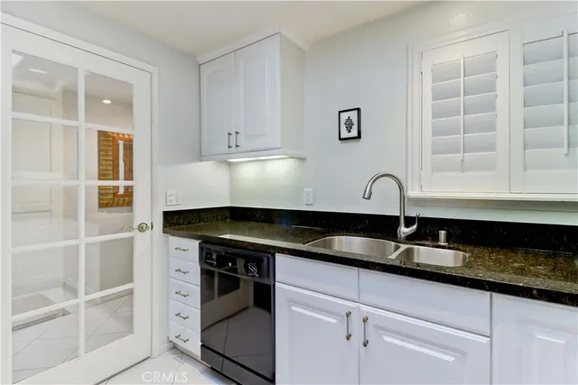 a kitchen with granite countertop a sink and a stove