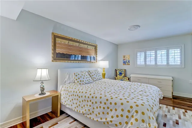 a bedroom with a bed a dresser and next to a window