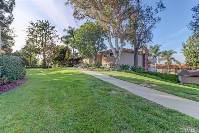a brick building with a big yard and large trees