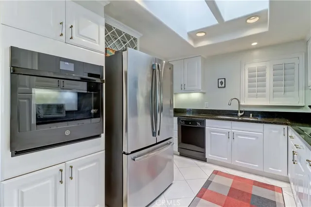 a kitchen with granite countertop a refrigerator and a sink