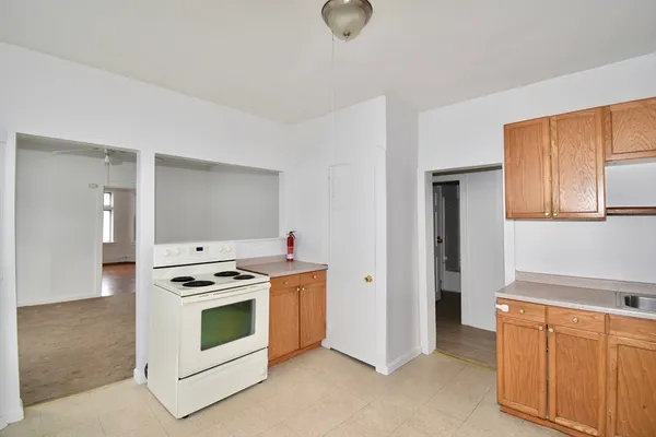 a kitchen with stainless steel appliances a stove and white cabinets