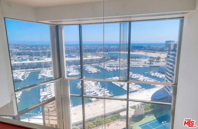 a room with lots of tables a large window and chairs