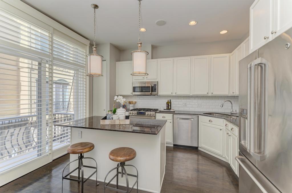 512 North Peoria Street Chicago, IL 60642 - Photo 13 of 32 a kitchen with granite countertop white cabinets and stainless steel appliances
