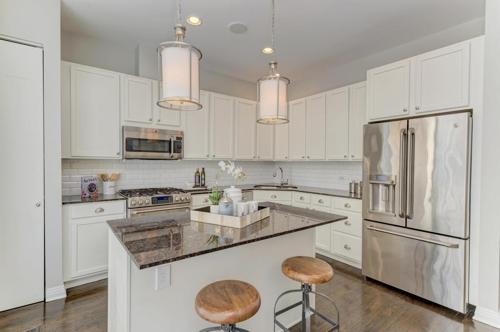 512 North Peoria Street Chicago, IL 60642 - Photo 14 of 32 a kitchen with stainless steel appliances granite countertop a sink a stove a refrigerator a microwave oven with white cabinets and wooden floor