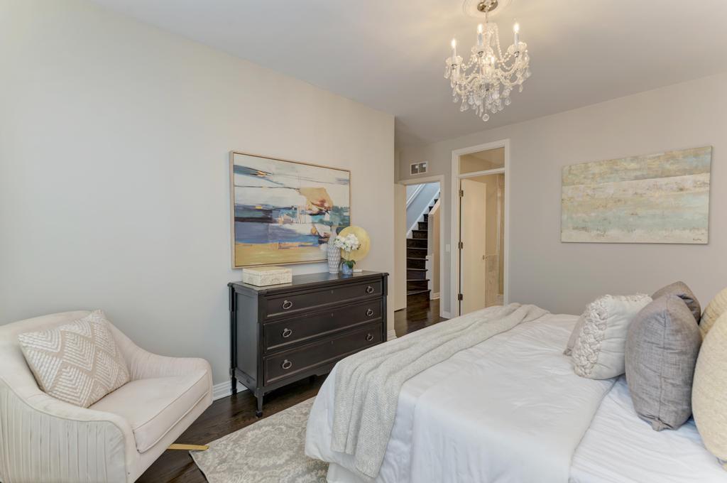 512 North Peoria Street Chicago, IL 60642 - Photo 20 of 32 a bedroom with a bed and a chandelier
