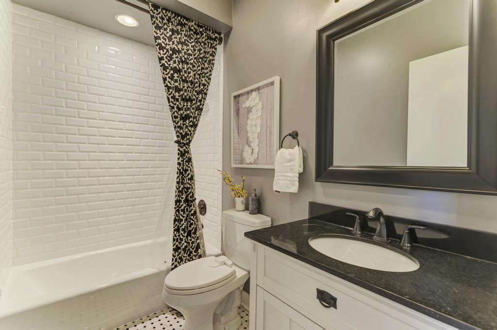 512 North Peoria Street Chicago, IL 60642 - Photo 27 of 32 a bathroom with a sink a toilet a tub and a mirror