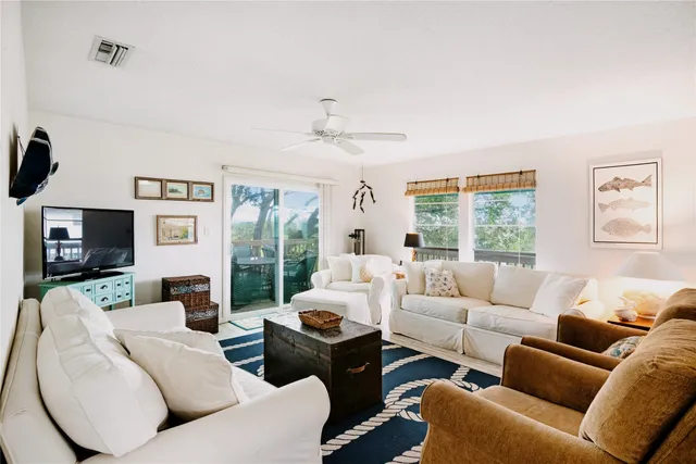 a living room with furniture a large window and a flat screen tv