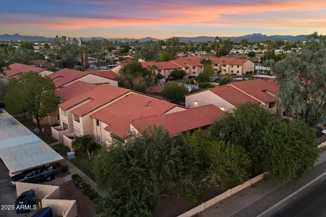 an aerial view of residential houses with outdoor space and trees