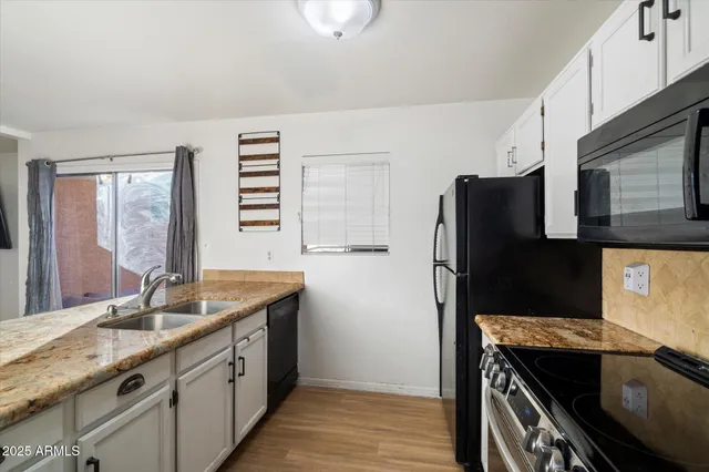 a kitchen with stainless steel appliances granite countertop a sink a refrigerator and a granite counter tops